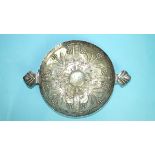 A white metal two-handled embossed shallow bowl decorated with flower heads around a central boss,