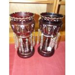 A pair of ruby glass lustre vases with gilt and white enamel decoration and clear glass drops,