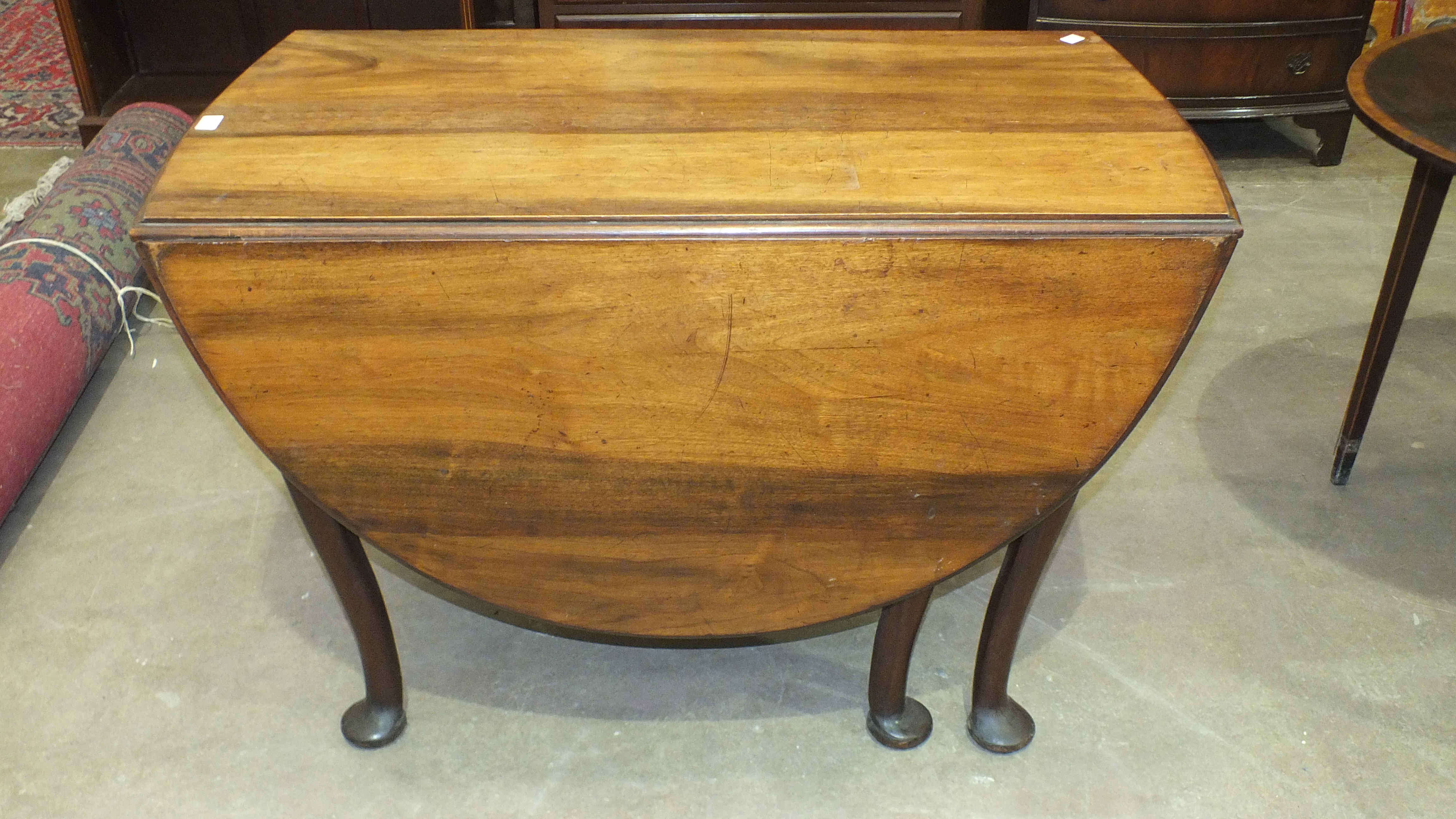 A walnut drop-leaf oval dining table, 105 x 146cm open, a Georgian cross-banded mahogany oval