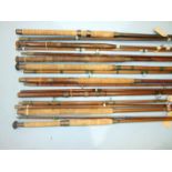 A collection of nine vintage greenheart boat rods, a whole cane beach caster rod and other rods, (