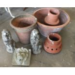 A lion's head fountain, a pair of concrete lion garden ornaments and four terracotta pots.