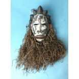 An unusual Gabon Punu pottery face mask, the face with characteristic hair braiding and raffia