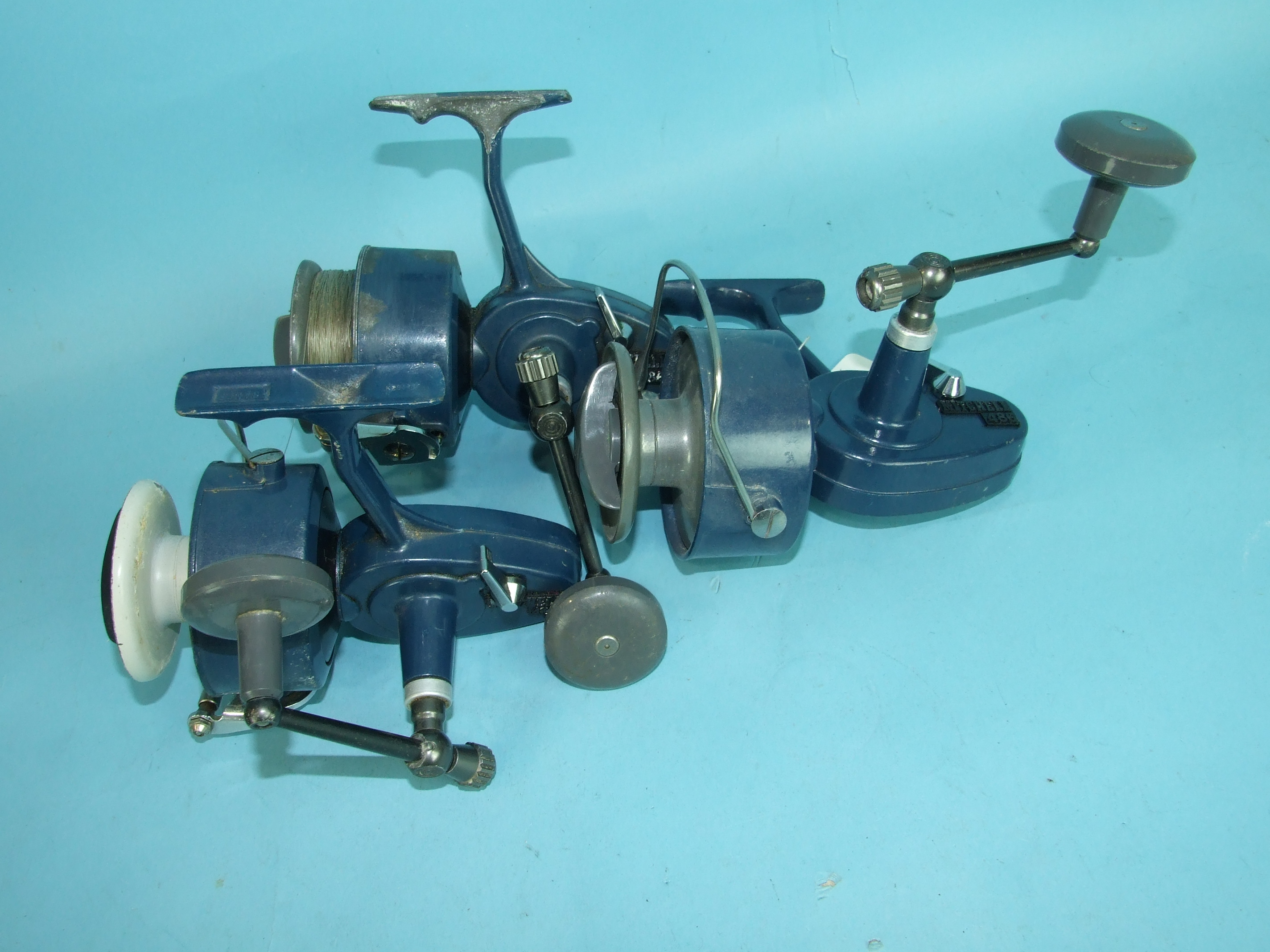 Three Mitchell No.486 fixed-spool spinning reels and other large fixed-spool reels, some damaged and