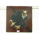 A pair of early-20th century Japanese lacquered panels decorated with birds and flowering trees,