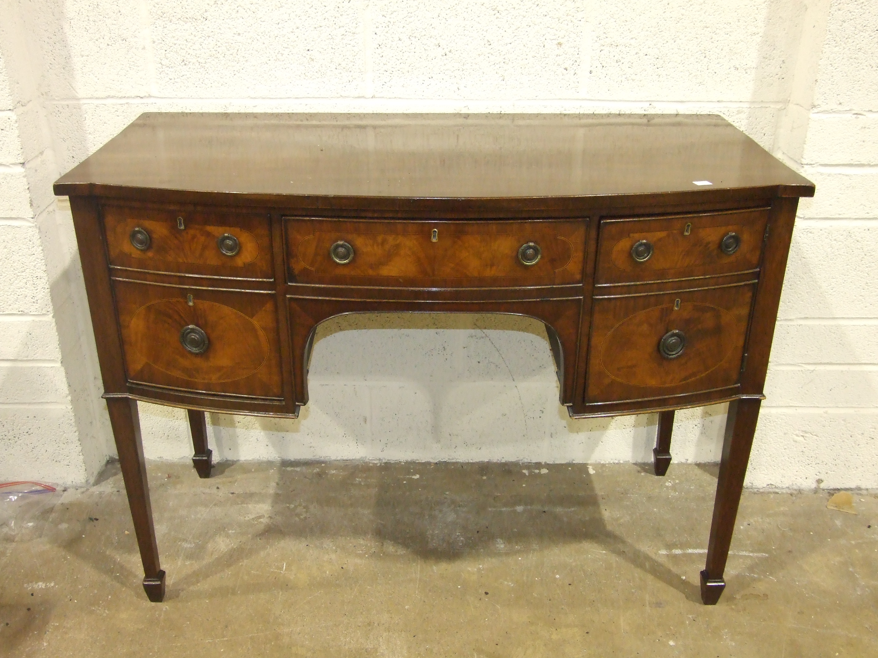 A Georgian-style inlaid mahogany bow-fronted small sideboard fitted with drawers and a cupboard,