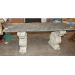 'A cast concrete garden bench on ram's head and acanthus supports, 124cm long, 50cm high.