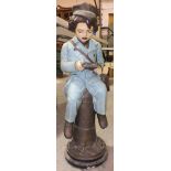 A painted plaster figure of a young boy seated on a bollard, Study, 64cm high, a Staffordshire