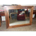 A large stained-wood framed wall mirror, 112 x 147cm and another modern bevelled wall mirror, 77 x