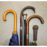 A silver-mounted walking cane, two walking sticks and two umbrellas, (5).