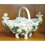 A late-19th/early-20th century German ceramic basket with handle and applied cherubs, floral and