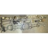 A collection of 21 old horse brasses mounted on leather straps and a collection of horse bits,
