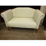 A small upholstered two-seater settee on stained beech claw and ball feet, 130cm wide.