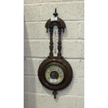 An Edwardian walnut aneroid barometer and thermometer, 55cm high.