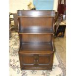 An Ercol-style draw-leaf dining table, a bookshelf 112 x 62cm and two dining chairs, (4).