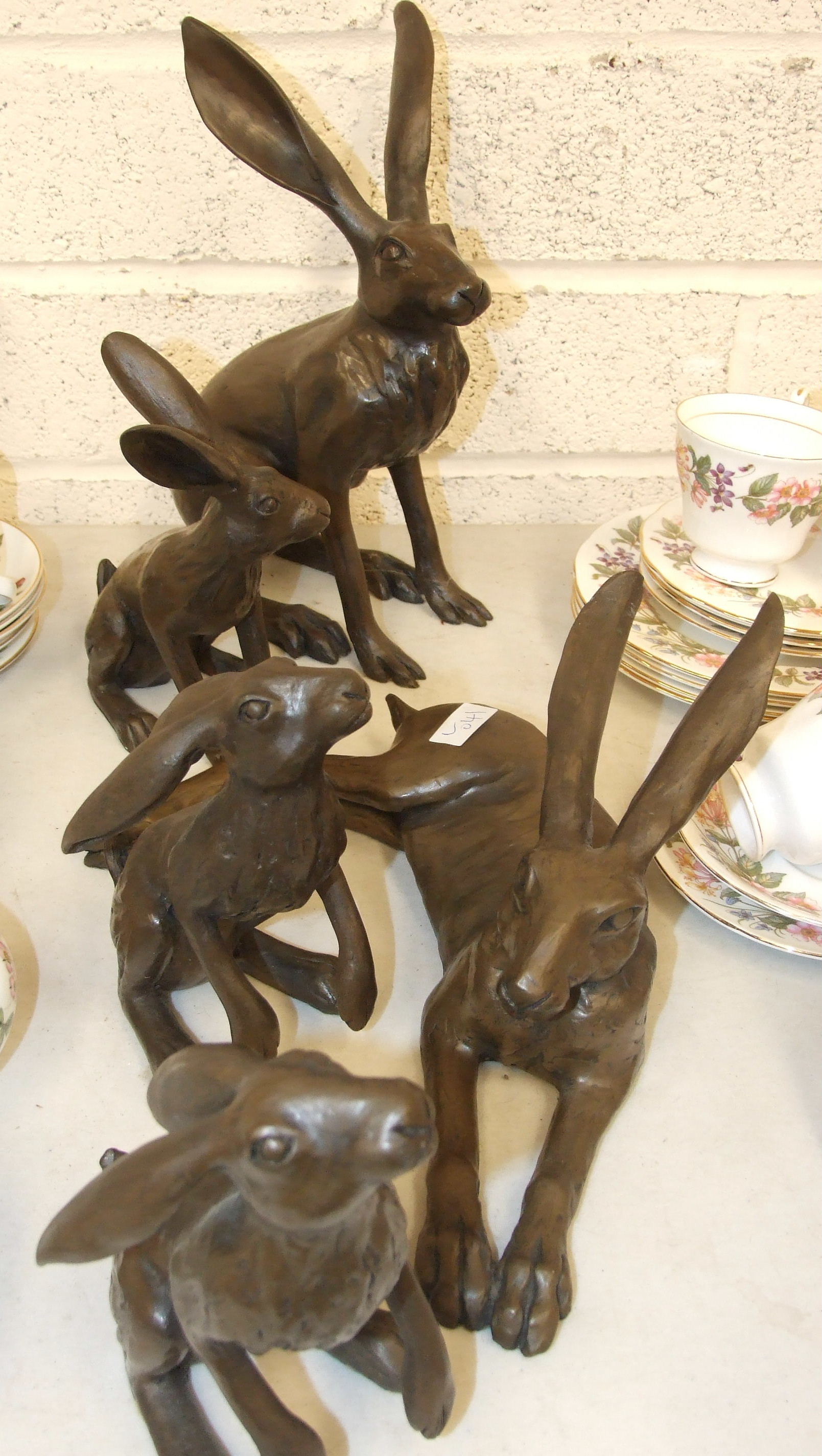 After Joanna Martins, a collection of five cold-cast bronzed resin models of hares, including '