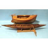 A scratch-built wooden model of a small dinghy, 51cm long and another of a dug-out canoe with