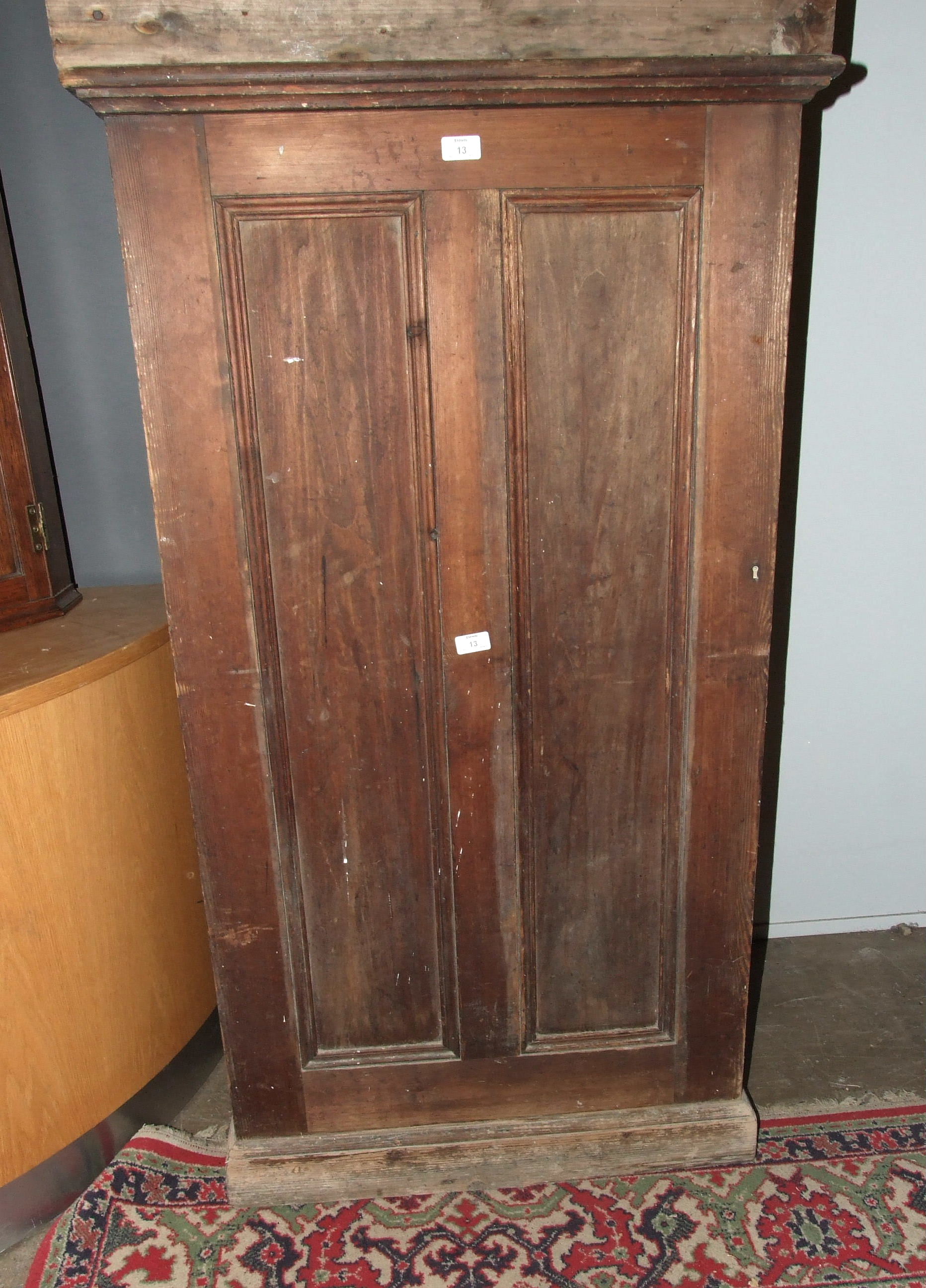 A stained wood freestanding cupboard, the panelled door opening to reveal four drawers, 75cm wide,