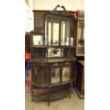 An Edwardian stained wood display cabinet fitted with bevelled glass doors, mirrors and shelves,