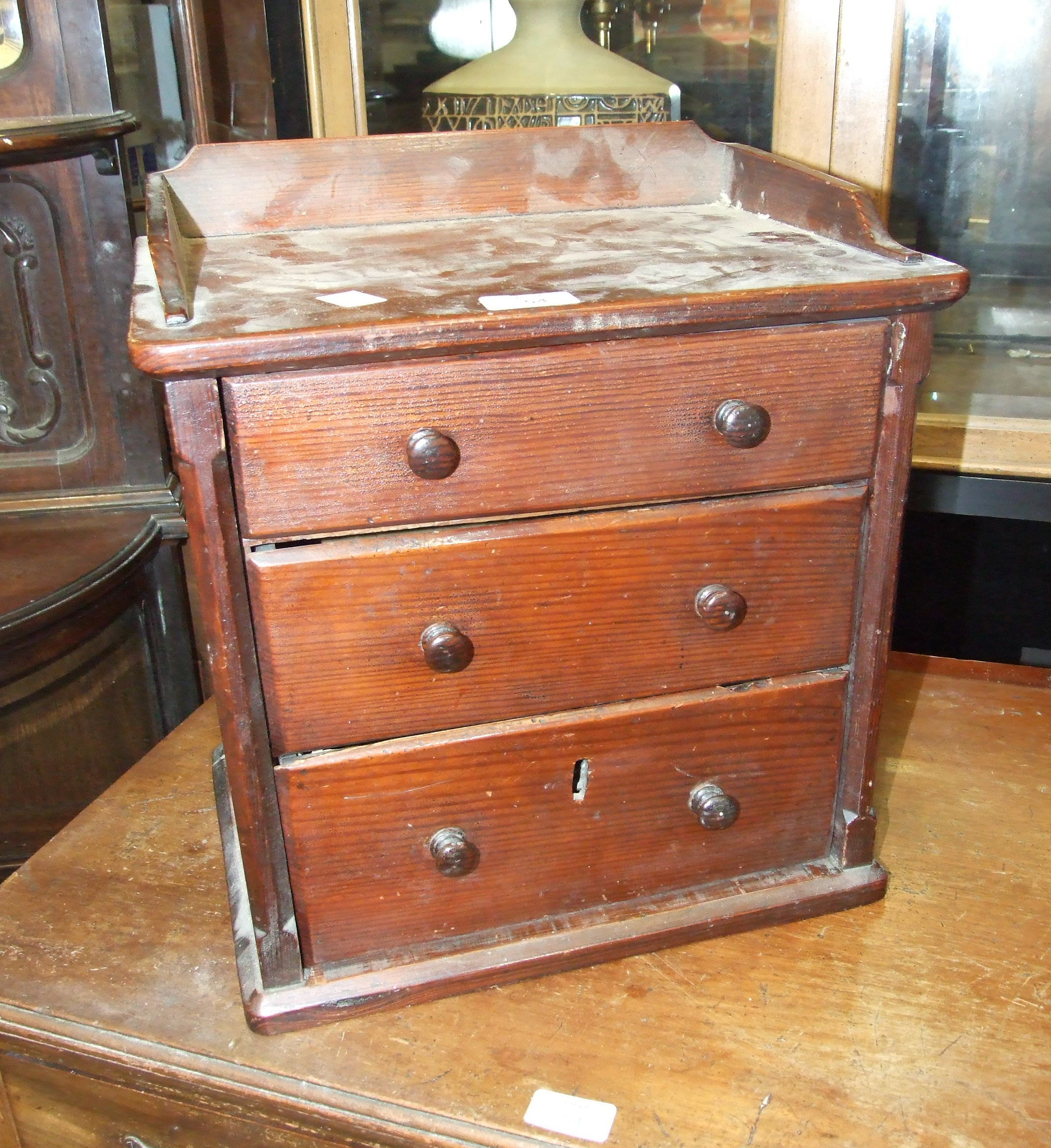 A Victorian pitch pine chest of three drawers, 36cm wide and a mahogany sewing table, (a/f), (2).