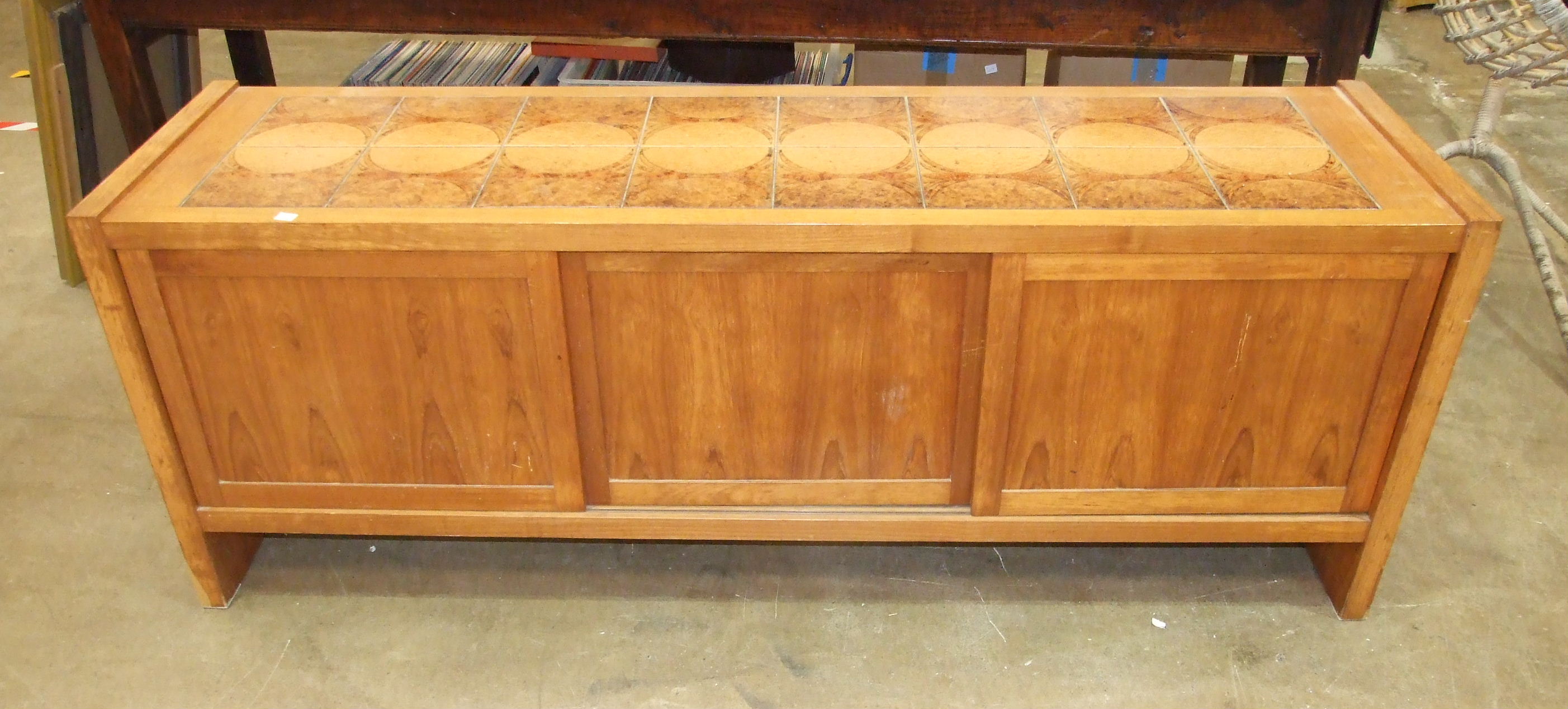 A retro hardwood low sideboard, with ceramic tiled top above three sliding panel doors, 190cm