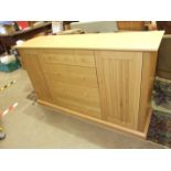 A modern oak storage cupboard fitted with four drawers and two cupboard doors, 150cm long, 86cm