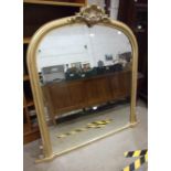 A modern gilt-painted over-mantel mirror of arch form, surmounted with a carved shell crest, 132cm