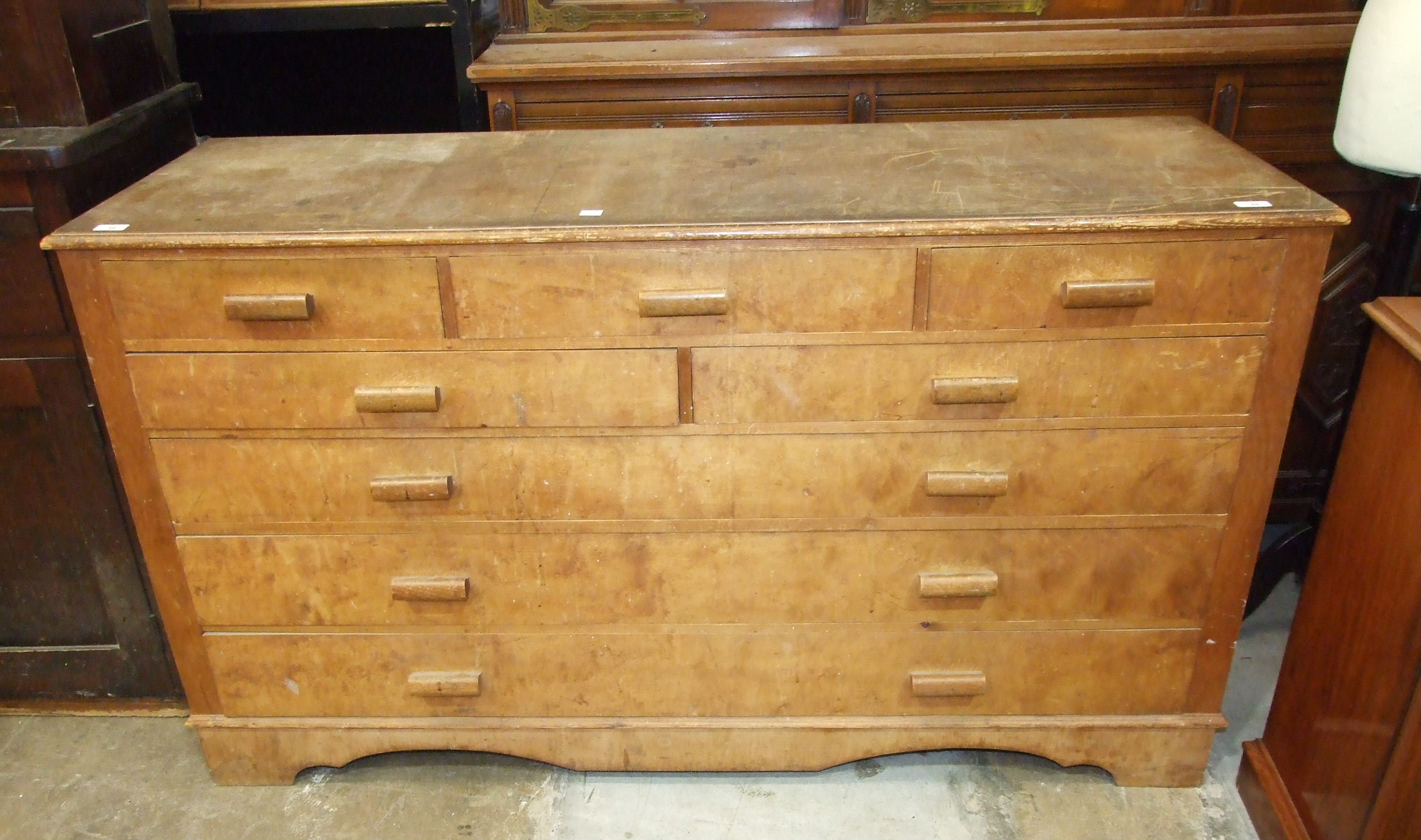 A veneered pine chest of five small and three long drawers, 154cm wide, 87cm high.