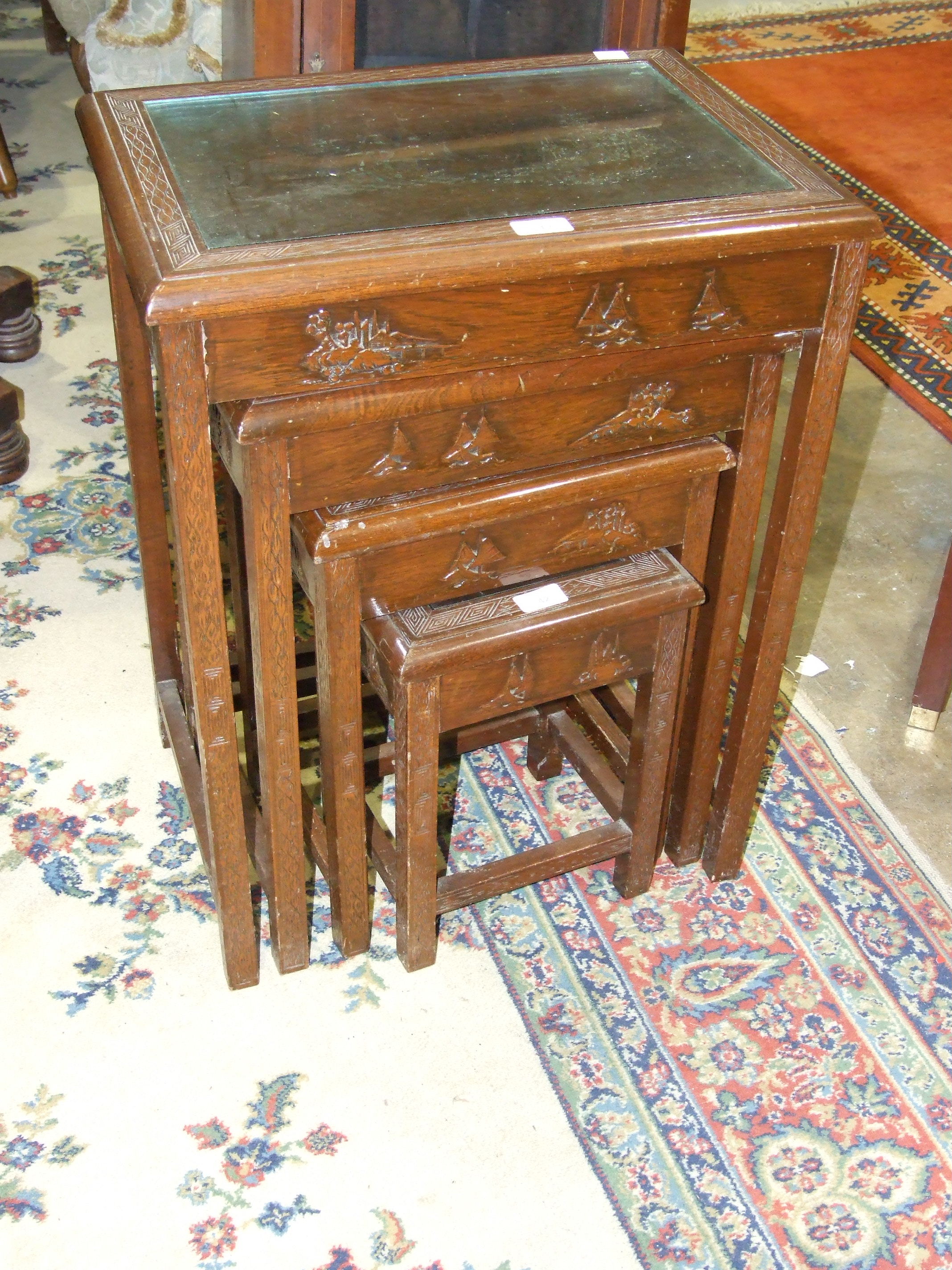 A nest of four Oriental hardwood tables, 51cm wide maximum.