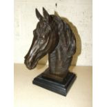 A bronzed metal sculpture of a horse's head, on black marble plinth, 31cm high.