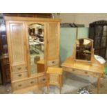 An early-20th century birds-eye maple wardrobe, the cornice above a central mirrored door flanked by