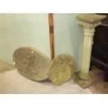 A cast concrete reeded pedestal column, 40cm high and two cast concrete oval decorative plaques, (