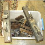 A collection of tools, including a wood plough plane, a brace and two wood-handled draw knives.