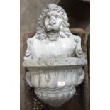 A cast concrete wall-mounted water feature in the form of a lion's head with font, 76cm high, 44cm