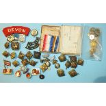 A small collection of military badges, Oxford University buttons, etc.