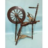 An early-19th century turned mahogany spinning wheel, (incomplete), 94cm high.