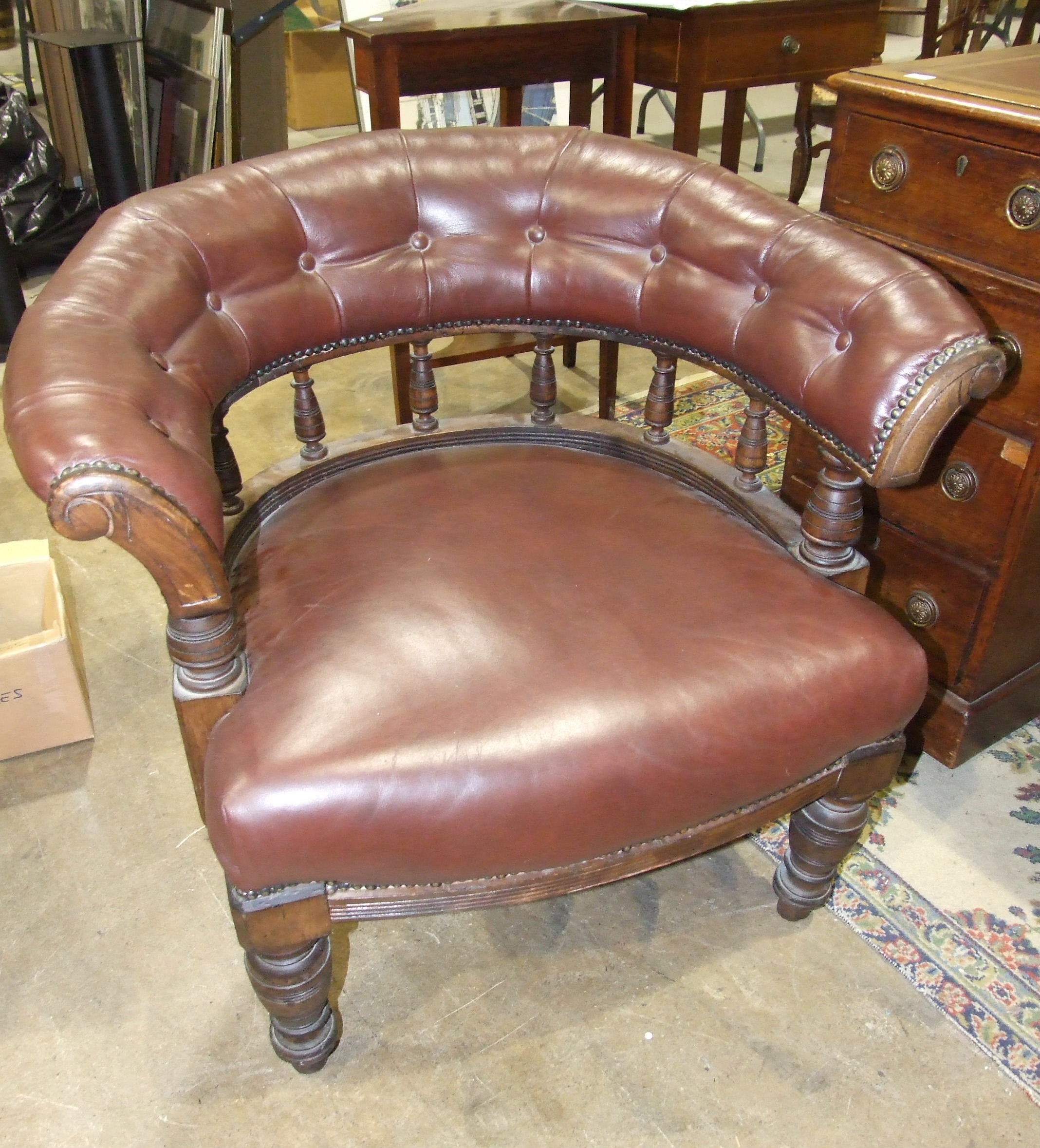 An Edwardian walnut button-back tub armchair, with upholstered rail, on turned spindles, the