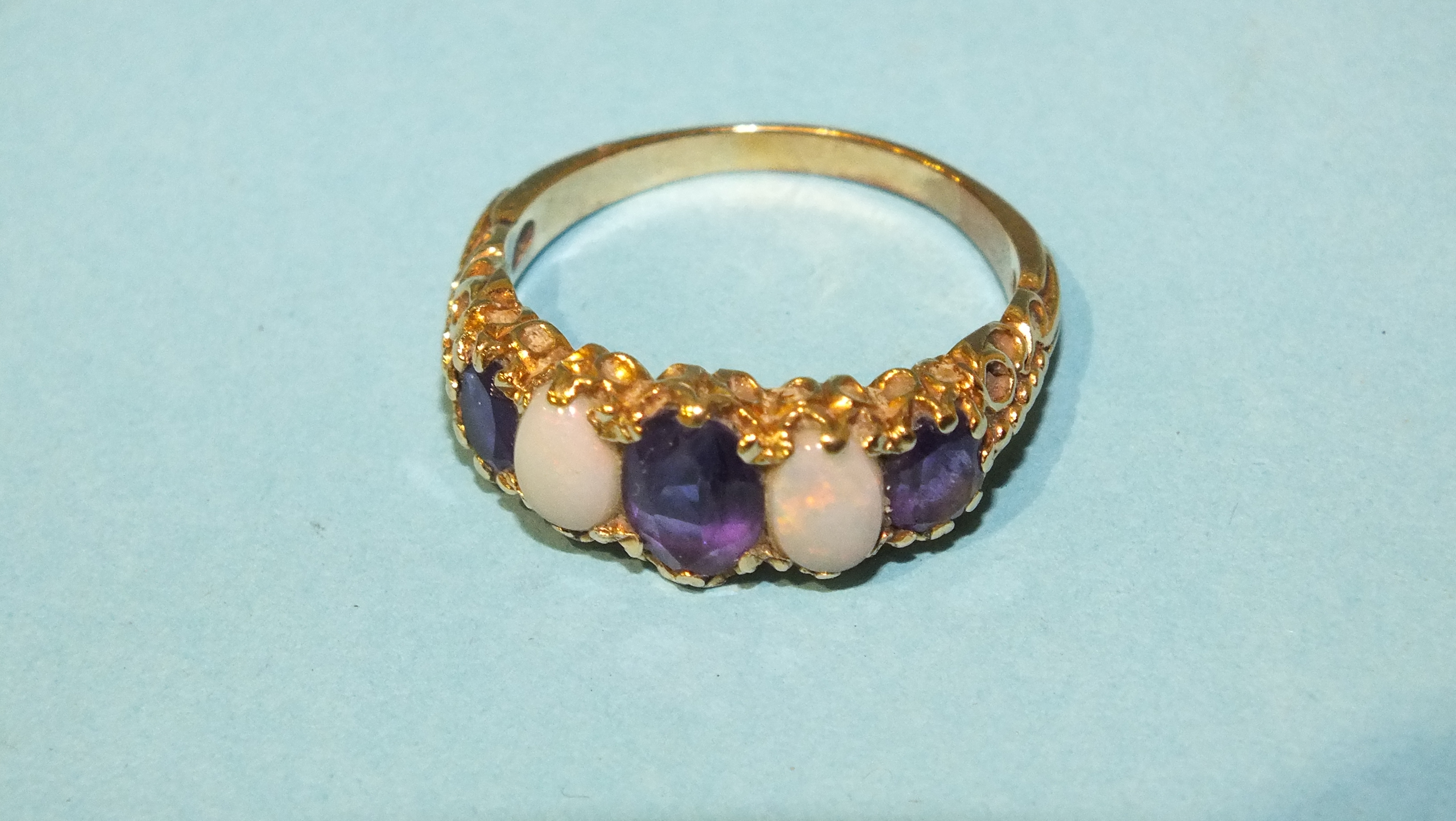 A 9ct gold ring set two opals and three graduated amethysts, size P, 3.6g.