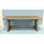 A bespoke oak refectory dining table, the pull-out top taking two extra leaves, with pierced end