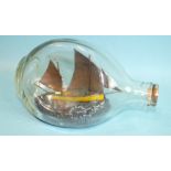 A ship model in a dimple bottle, 'The Fowey Lugger FY54', detail includes a gull and fishing buoy,