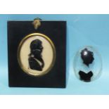 A late-18th century silhouette painted on convex glass in black of a young naval officer, possibly