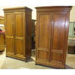 A pair of late-19th century Continental walnut wardrobes, each with single panelled door, moulded