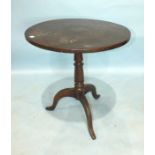 An 18th century oak tilt-top table, the circular top with iron catch, turned column and tripod