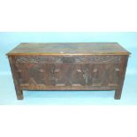 An antique oak coffer, the carved frieze above panels with applied moulding bearing date 1699 and