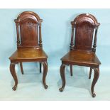 A pair of Victorian mahogany hall chairs, each arched carved splat-back flanked by fluted columns to