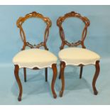 A set of six Victorian walnut dining chairs, each open and pierced carved back with plain