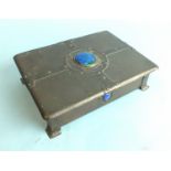 An Arts & Crafts copper box with hinged lid and wood-lined interior, with applied strap-work