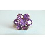 A 9ct gold ring set seven-stone amethyst flower head cluster, size O, 3.9g.