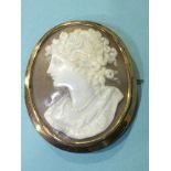 A shell cameo brooch portraying the bust of a young woman with flowers in her hair, in 9ct gold