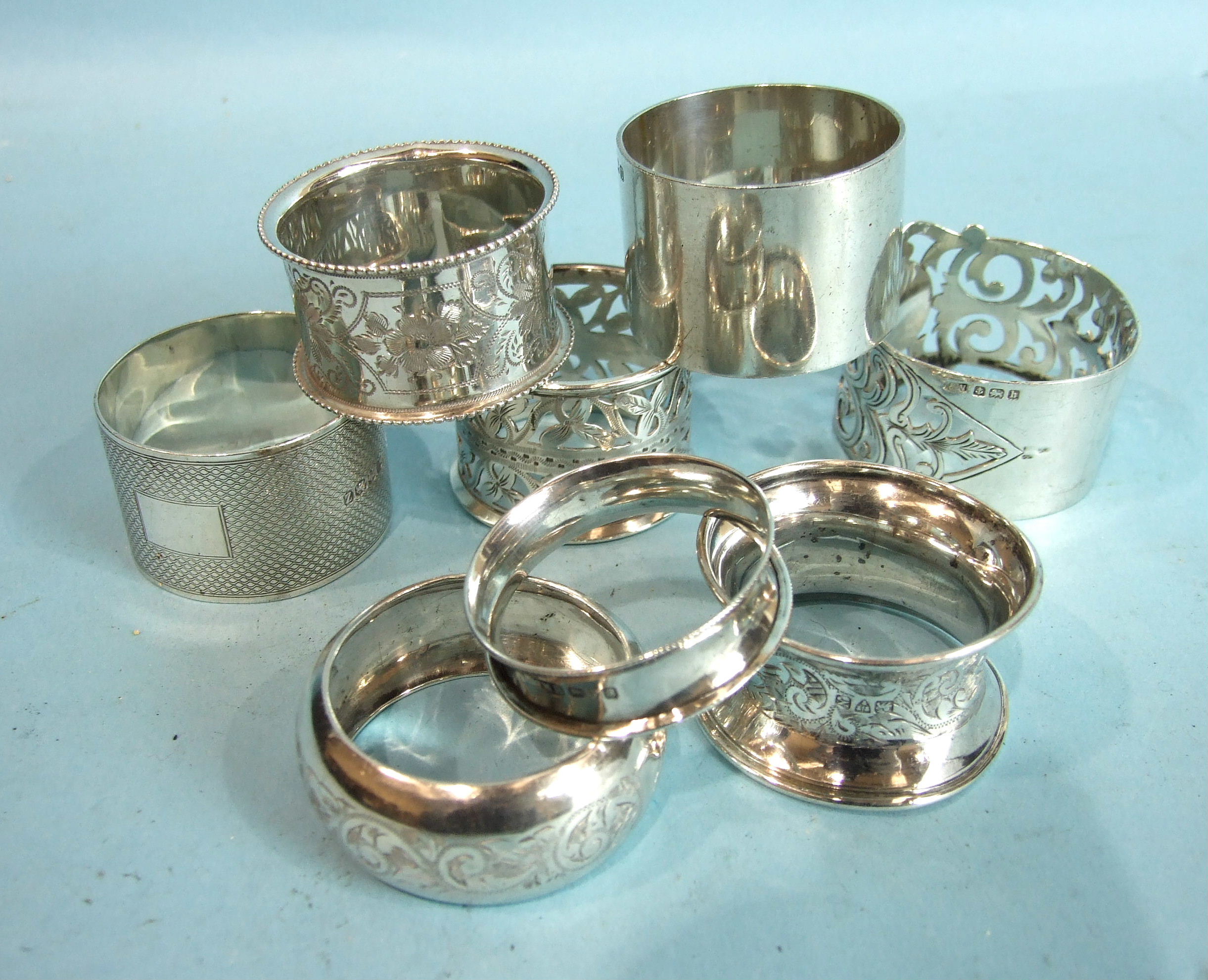 A collection of eight late-19th and 20th century napkin rings of various designs, ___6oz.