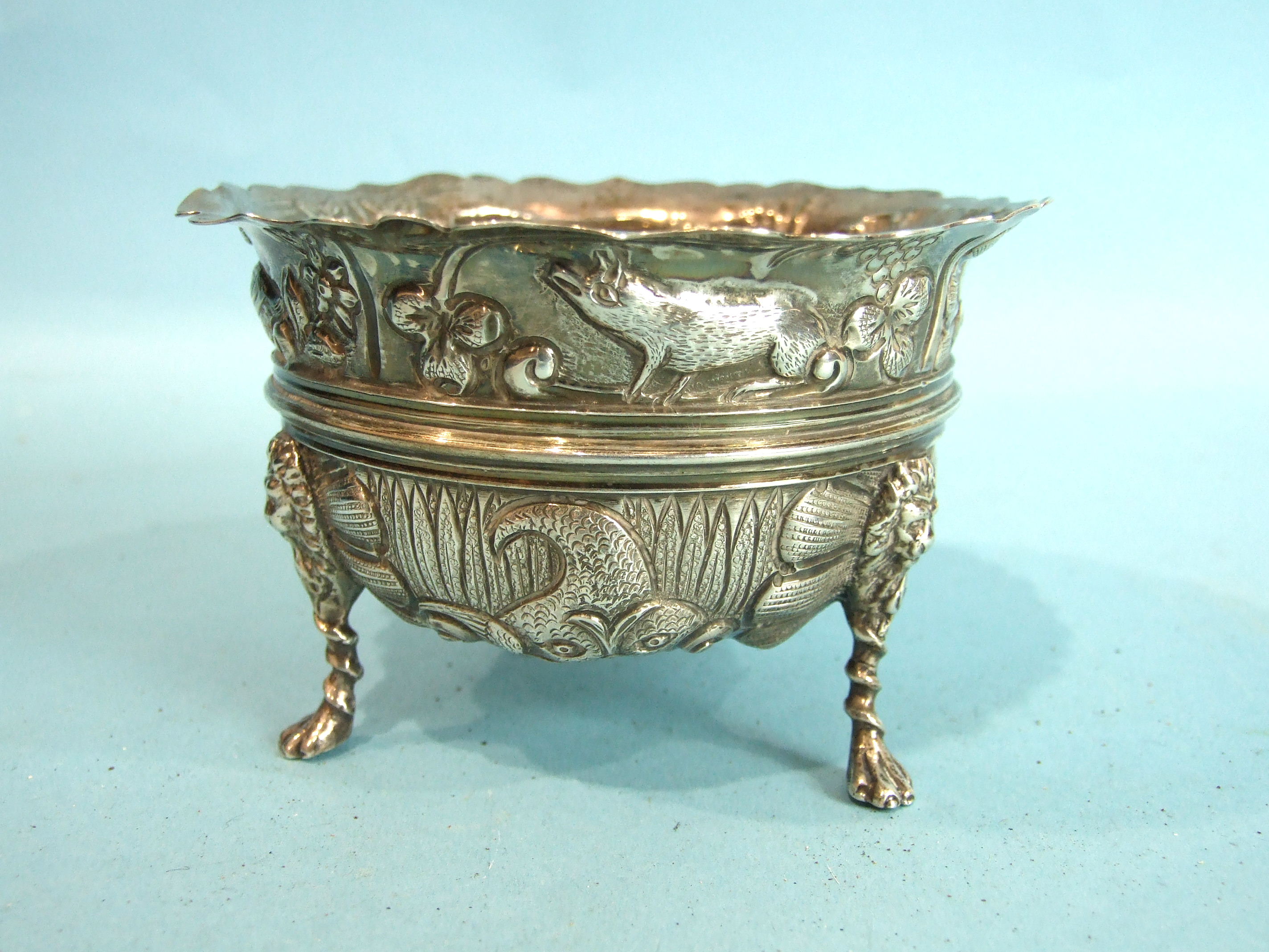 A late-Victorian sugar bowl embossed-overall with swans and pigs, on lion mask and paw feet, 11.